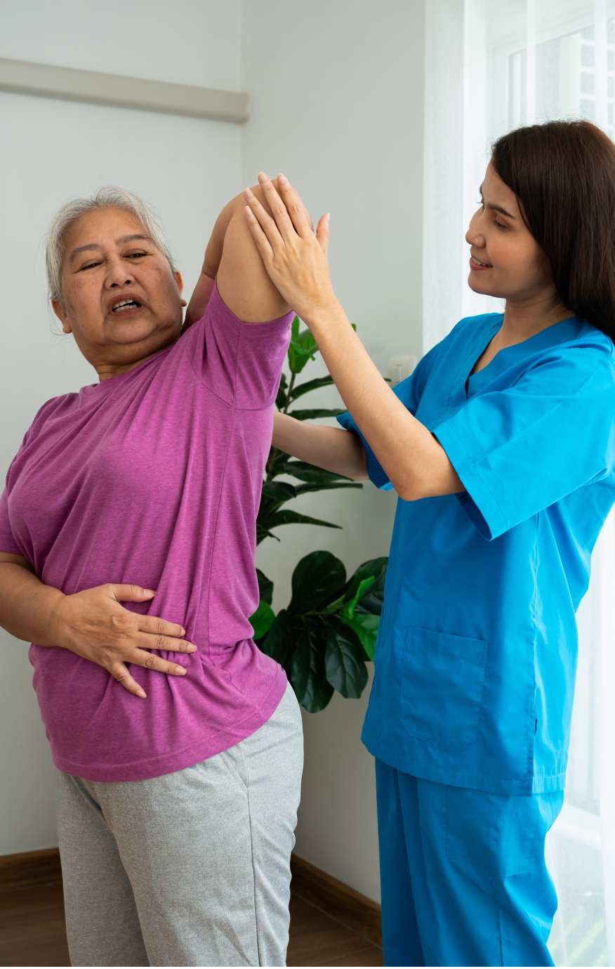 Post-hospital care patient receives help from her caregiver while performing exercises.