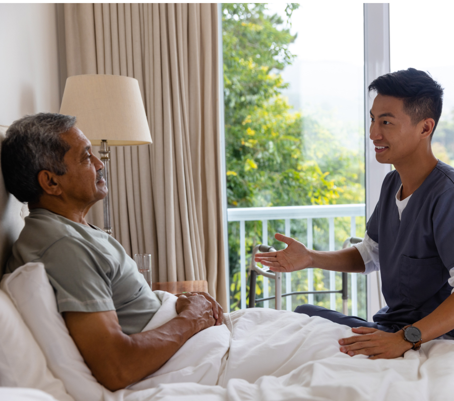 A home care client sits and listens to the suggestions of his smiling caregiver.