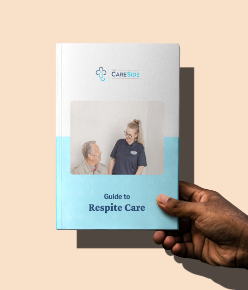 Hand holding The CareSide's guide to Respite Care.