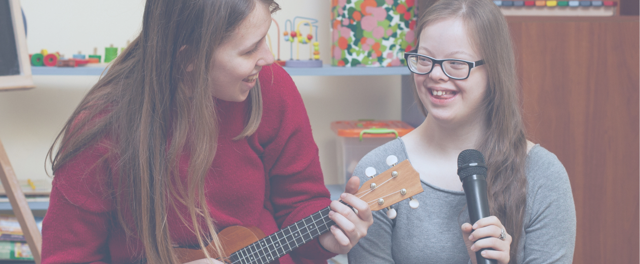 Young girl smiles while playing music with her teacher as part of her NDIS Improved Daily Living supports.