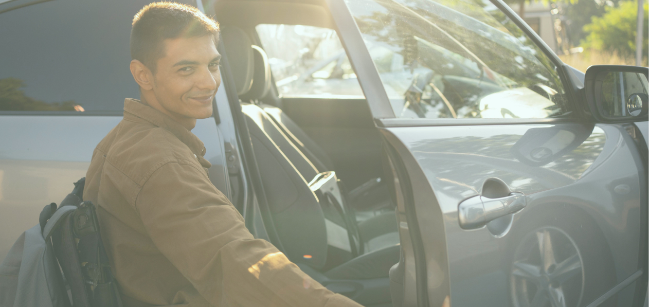 NDIS participant smiling at the camera while receiving transport assistance.