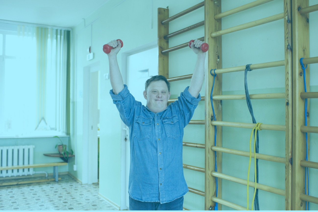 A young man holds weights above his head.