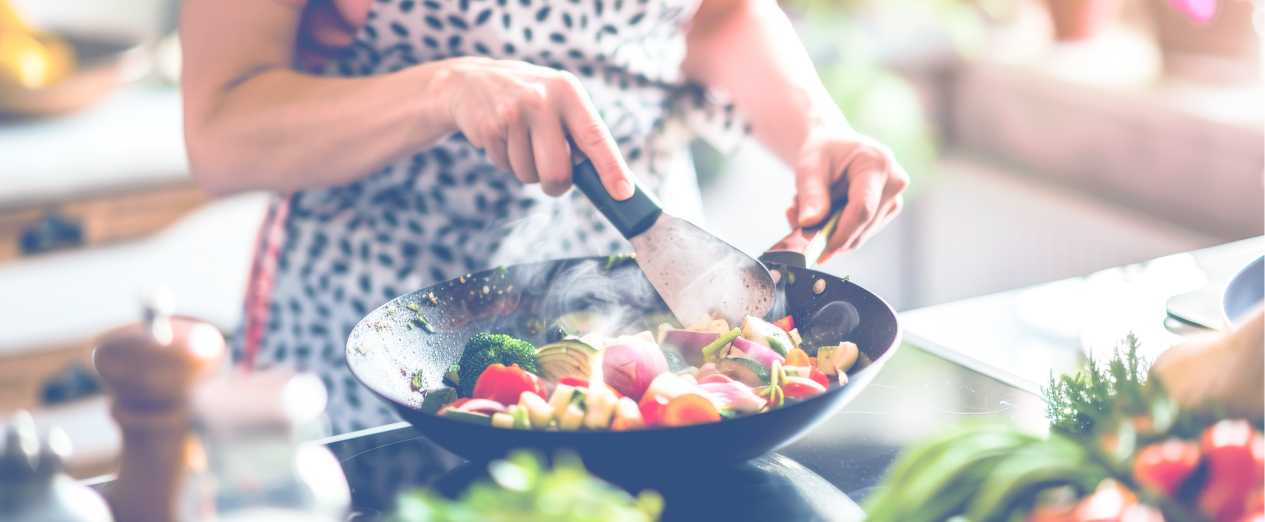 A woman prepares a healthy meal, which is a skill covered by NDIS Capacity Building Supports.