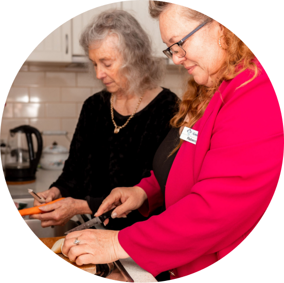 Caregiver from The CareSide provides companion care while preparing food with her client in the kitchen.