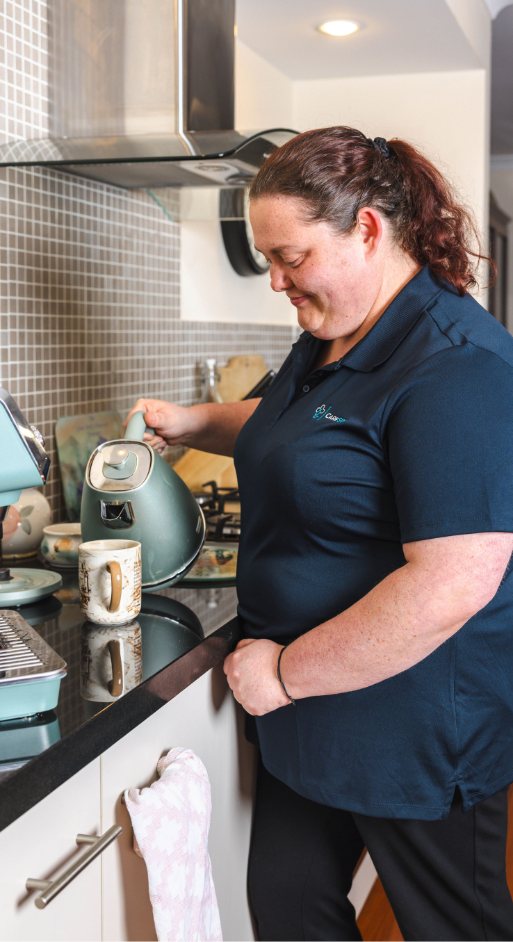 A caregiver from The CareSide providing personal care support while pouring a cup of tea.